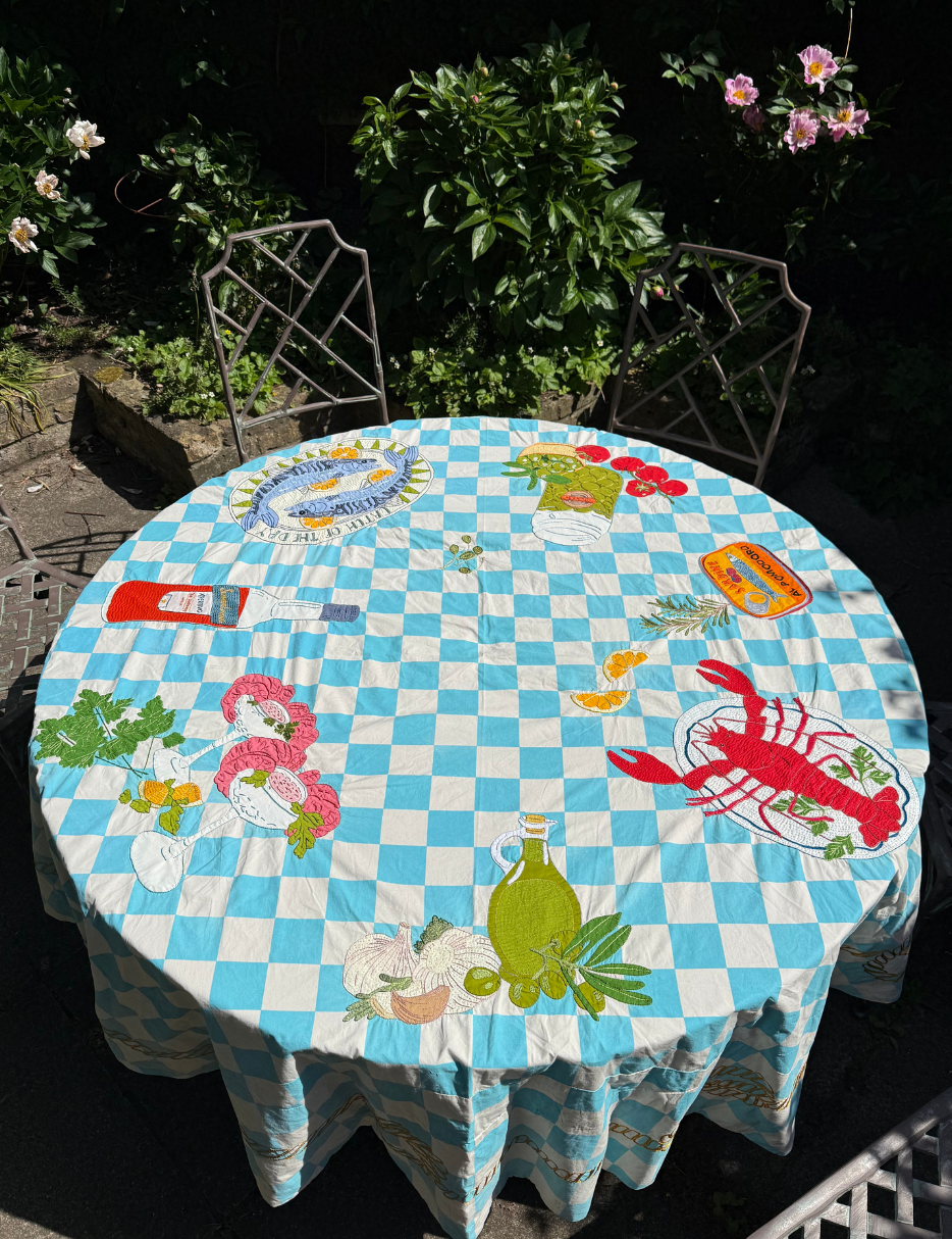 Block print embroidered tablecloth on garden table outside 