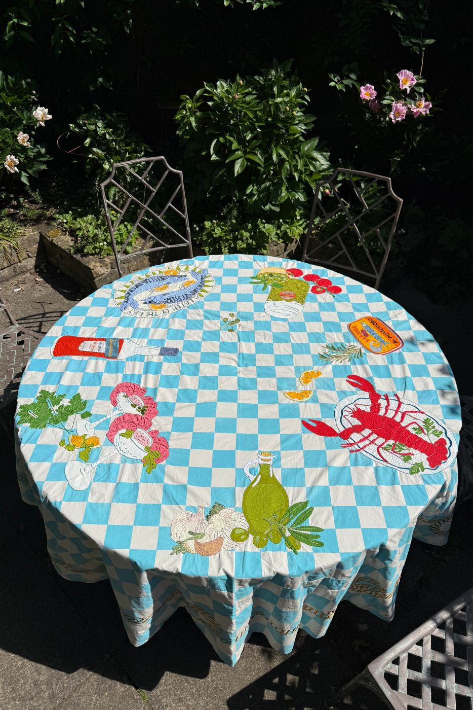 Block print embroidered tablecloth on garden table outside 