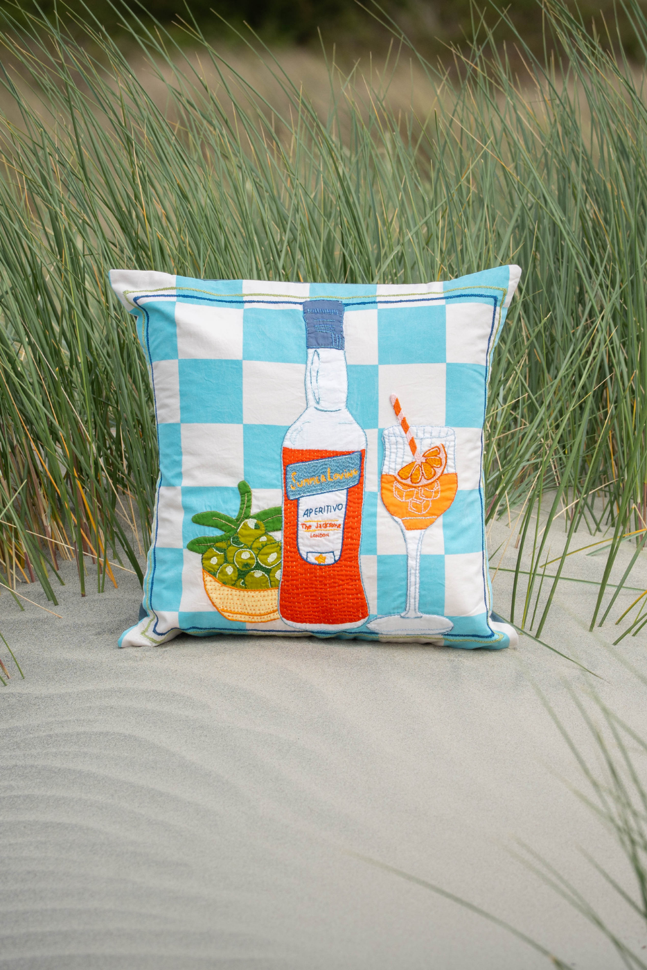 embroidered cushion with aperol and olives 