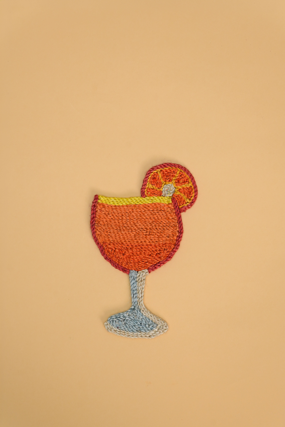Aperol Spritz coaster, with orange slice. The coaster is made from Jute