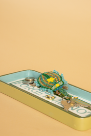  A green blue and white striped hall tray, which is hand painted with forget me not written in elegant lettering. A green beetle beaded keyring   with a yellow star motif  