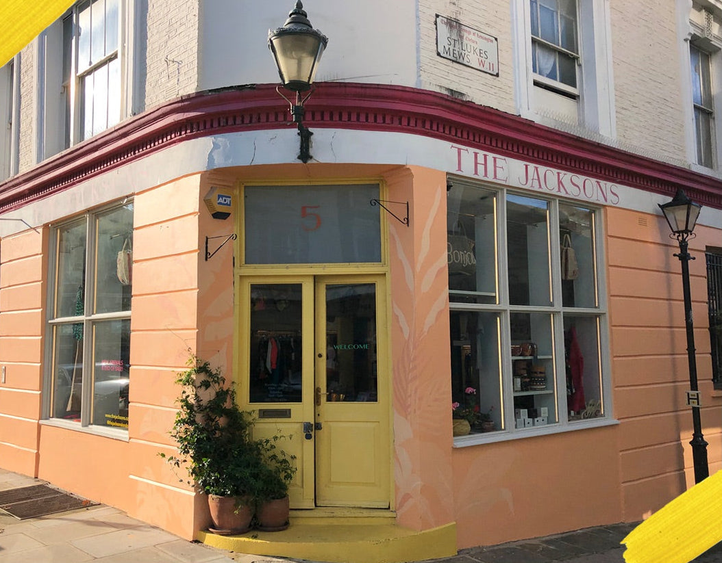 Corner of a shop building with 'The Jacksons' sign and yellow door